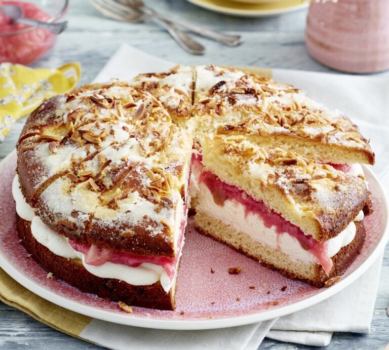 Auf einem Teller ist ein gefüllter Rhabarber-Butterkuchen angerichtet. Er ist mit Puderzucker bestreut. | © EAT CLUB / Isabell Triemer