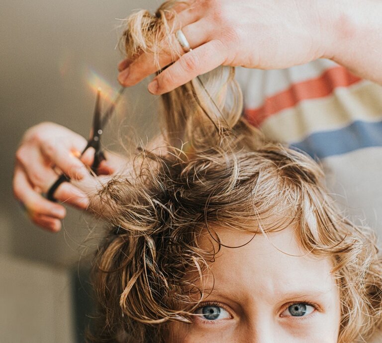 Einer jungen Frau werden die Haare geschnitten | © Getty Images / Catherine Falls Commercial