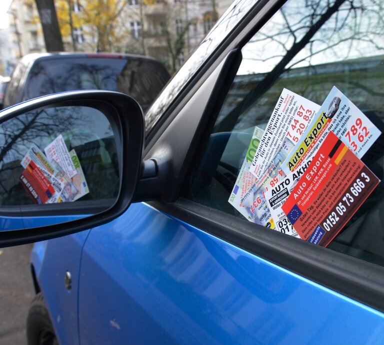 Geparktes, blaues Auto mit Ankaufkarten an der Scheibe. | © IMAGO / Schöning