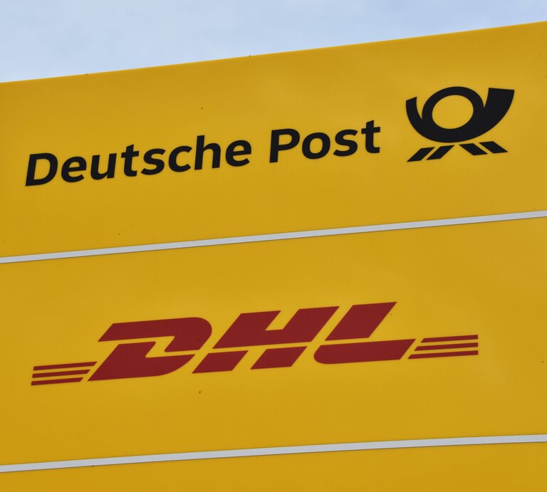 Das typisch gelbe Schild der Deutschen Post, darunter eines von DHL | © IMAGO / Revierfoto