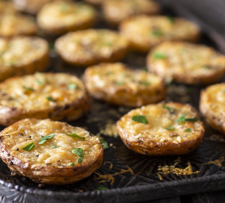 Parmesan-Kartoffeln auf einem Backblech, mit Käse überbacken. | © Getty Images/ rudisill