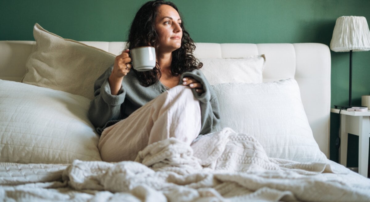 Frau mit Erkältung im Bett