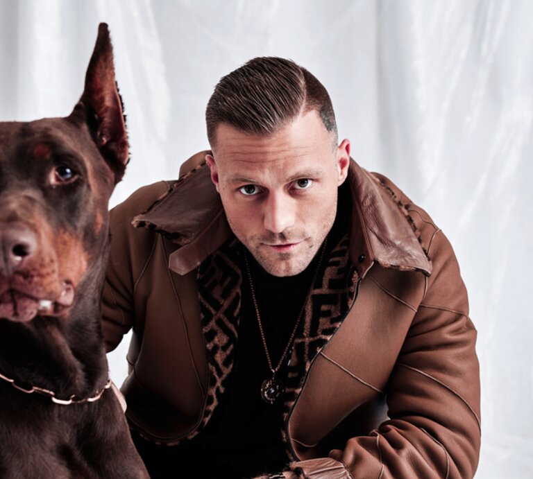Rapper Kontra K  mit einem Hund an seiner Seite | © über Spoton