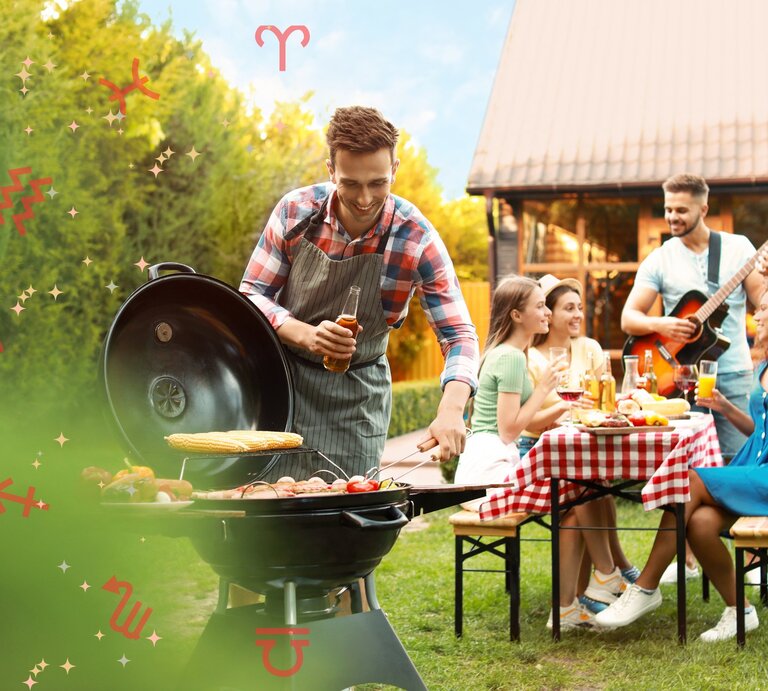 Ein fröhlicher Mann in einem karierten Hemd und einer Schürze grillt auf einem Grill im Freien, während er ein Getränk hält. Hinter ihm genießt eine Gruppe von Freunden ein Picknick mit einem gedeckten Tisch mit einer rot-weißen Tischdecke. Einer spielt Gitarre, während die anderen lachen und sich unterhalten. Der Hintergrund ist ein grüner Garten und ein Haus mit einem roten Dach an einem sonnigen Tag. Über dem Bild sind verschiedene Symbole verteilt, die die Sternzeichen darstellen. | © Adobe Stock / New Africa und Chikovnaya