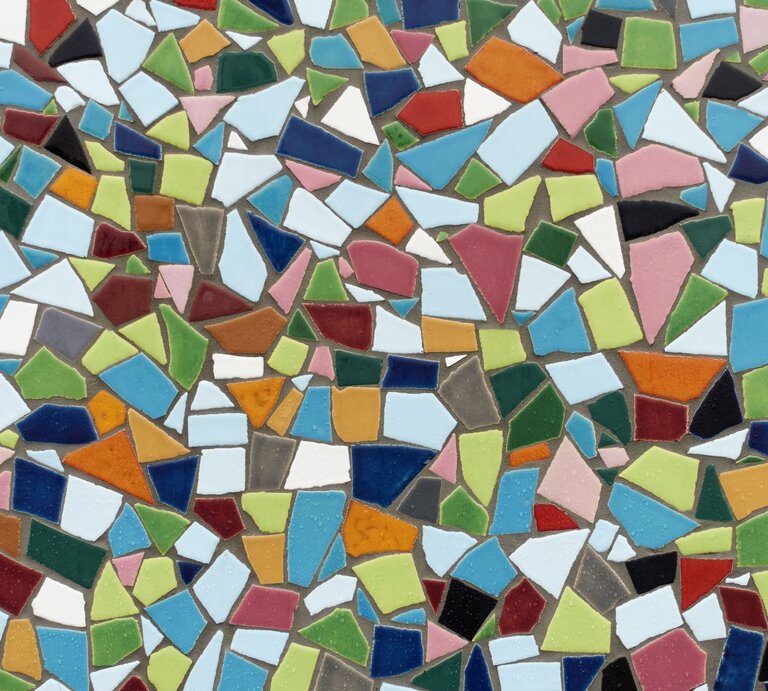 Bunte Mosaikfliesen in verschiedenen Formen und Farben sind dicht aneinandergereiht und bilden ein lebendiges, abstraktes Muster. | © Getty Images/acilo