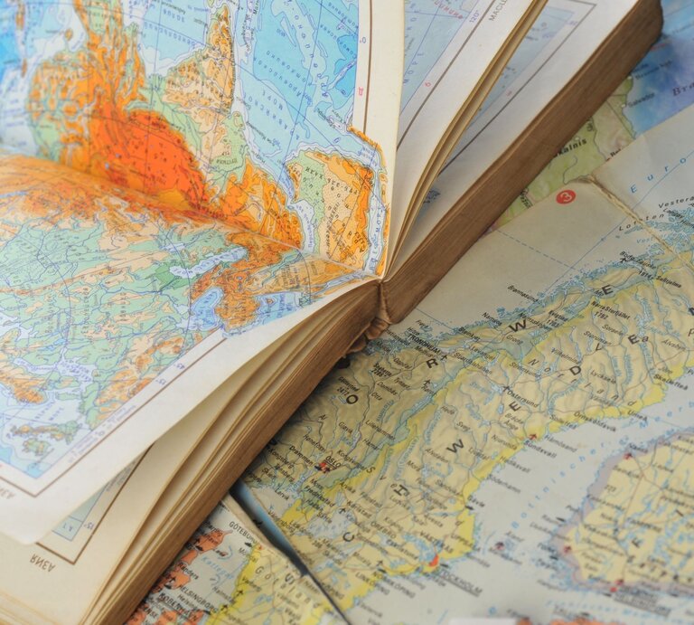 Nahaufnahme eines geöffneten Atlanten, der Karten von Nordeuropa und Russland zeigt. | © Adobe Stock/Denis Tabler
