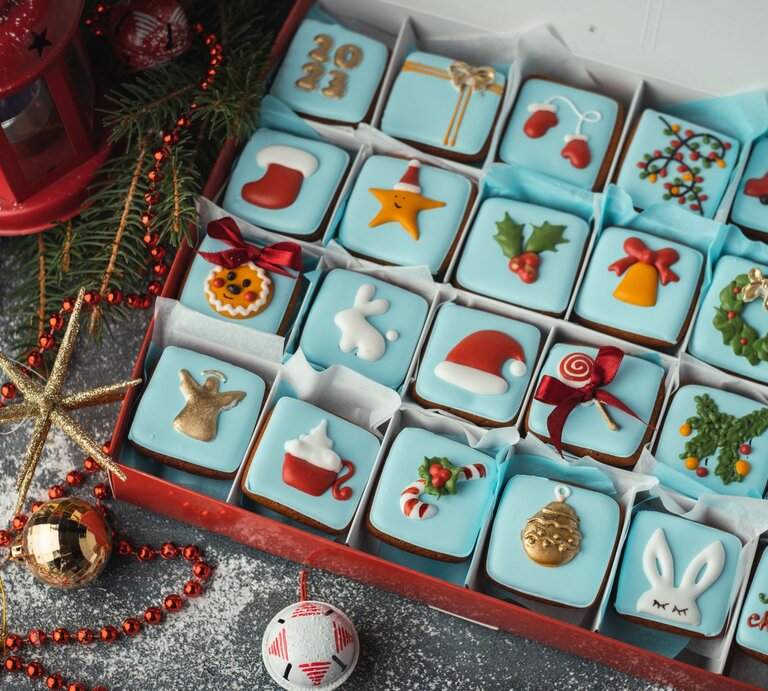 Detailreicher Adventskalender mit 24 bunt verzierten Weihnachtskeksen in Blau, Rot und Gold in festlicher Geschenkbox. | © Shutterstock/alexanderon