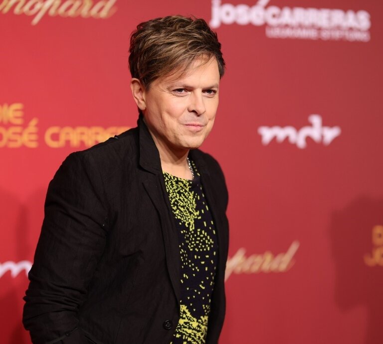 Sänger Michael Patrick Kelly lächelt auf einem Roten Teppich in die Kameras  | © Getty Images