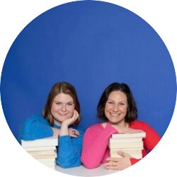 Zwei Frauen mit Büchern sitzen vor einem blauen Hintergrund. | © Ulrike Schacht