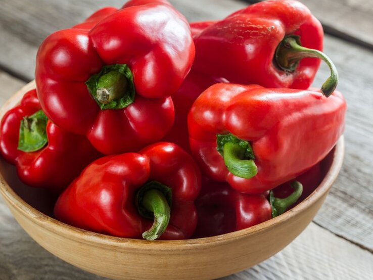 Rote Paprika in einer Holzschale – echte Vitamin-C-Bomben, die sogar Orangen übertreffen und das Immunsystem stärken. | © Getty Images Pro/ AlexPro9500 via Canva.com