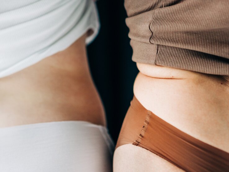 Ungewollte Gewichtszunahme ist ein häufiges Symptom der Wechseljahre. Zwei Frauenkörper in der Bauchmitte