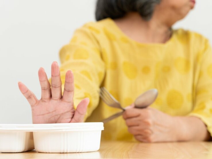 Frau schiebt eine Schüssel mit Essen von sich weg. | © Prot – stock.adobe.com