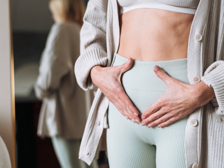 Frau, die sich den Unterbauch hält.