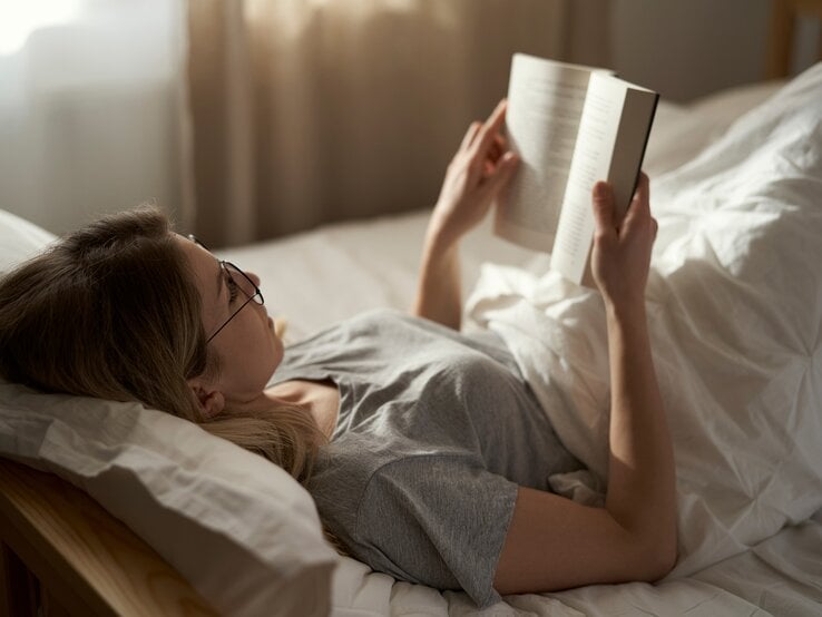Frau liest im Bett ein Buch | © gpointstudio – stock.adobe.com