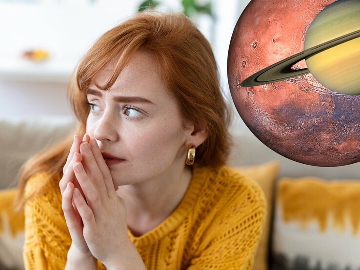 Eine besorgte rothaarige Frau in einem gelben Pullover sitzt drinnen, die Hände gefaltet, und schaut nachdenklich zur Seite. Direkt neben ihrem Kopf ist eine überdimensionale Darstellung des Planeten Mars mit dem Ring von Saturn montiert, als ob sie im Weltraum schweben und ein Fenster zur kosmischen Szene darstellen.