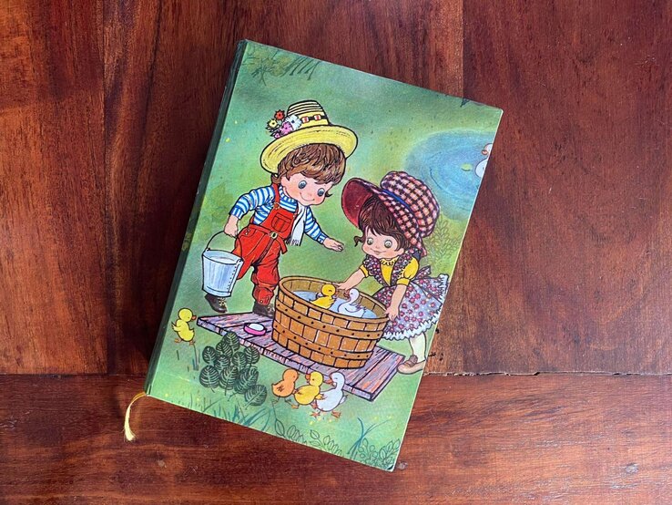 tagebuch (2).jpg | © Privatarchiv Ein grünes kleines Buch mit zwei gezeichneten Kindern liegt auf einem Holztisch. | © Privatarchiv