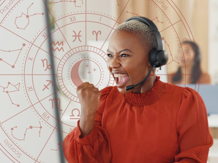 Eine Frau mit dunkler Hautfarbe und kurzen Haaren sitzt mit einem Kopfhörer vor einem Monitor und ball die Hand zu einer Siegerfaust. Ihr Gesichtsausdruck ist kraftvoll und glücklich.