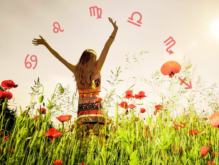 Eine Frau steht in einem blühenden Mohnblumenfeld und streckt freudig die Arme nach oben in den Himmel. Die Sonne scheint hell und der Himmel ist klar. Um die Frau herum sind verschiedene astrologische Symbole in einer gebogenen Linie dargestellt. Die Atmosphäre wirkt sommerlich und unbeschwert.