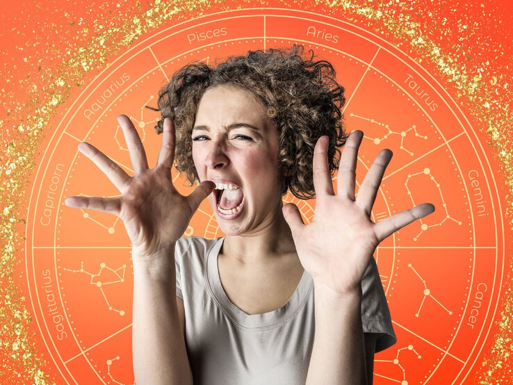 Eine junge Frau mit lockigem Haar hebt erschrocken beide Hände und schreit. Im Hintergrund befindet sich ein orangeroter astrologischer Kreis mit den Symbolen und Konstellationen der zwölf Tierkreiszeichen, verziert mit goldenen Glitzereffekten."