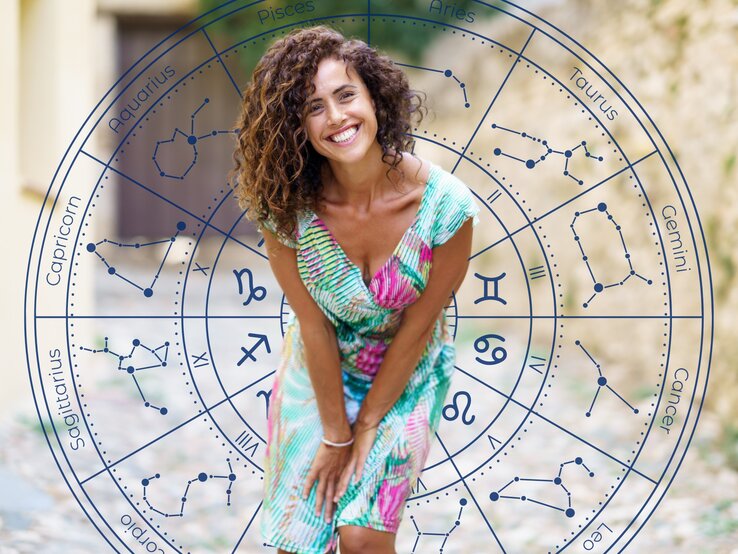 Eine lachende Frau mit lockigem Haar trägt ein buntes Sommerkleid und steht draußen auf einem gepflasterten Weg. Im Hintergrund befindet sich ein astrologischer Kreis mit den Symbolen und Konstellationen der zwölf Tierkreiszeichen, dargestellt in Blau.