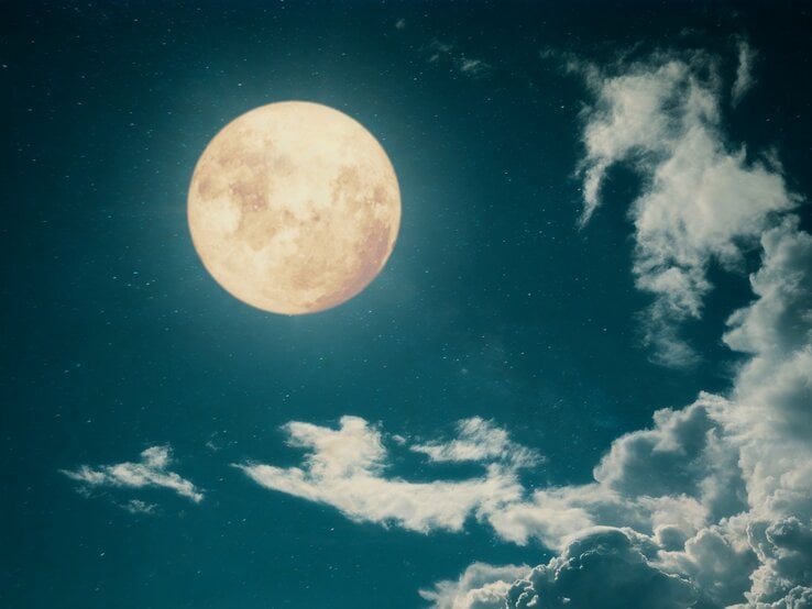 Ein großer, leuchtender Vollmond am Nachthimmel, umgeben von Sternen und sanften, weißen Wolken. Der Himmel ist tiefblau und erzeugt eine ruhige, mystische Atmosphäre.