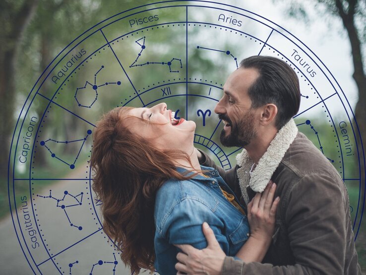 Ein lachendes Paar genießt einen romantischen Moment im Freien. Die Frau mit roten Haaren lehnt sich zurück, während der Mann sie sanft hält und beide sich strahlend ansehen. Im Hintergrund überlagert eine astrologische Tierkreisgrafik mit Sternzeichen und Konstellationen das Bild. Die Szene vermittelt Leichtigkeit, Spaß und eine verspielte, flirtende Energie, passend zum Thema Liebeshoroskop oder Flirtastrologie.
