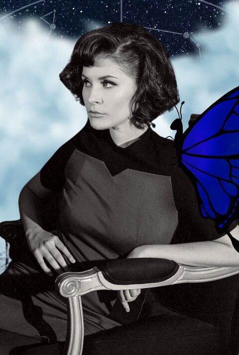 Eine stilvoll gekleidete Frau mit einem eleganten Retro-Look sitzt in einem antiken Sessel und blickt nachdenklich zur Seite. Ihr Bild ist in Schwarz-Weiß gehalten, während der Hintergrund ein kosmisches Sternenbild mit astrologischen Symbolen zeigt. Ein großer, leuchtend blauer Schmetterling sitzt auf ihrer Schulter. Die Szene wirkt mystisch und symbolisiert möglicherweise Transformation, innere Reflexion oder einen bedeutenden Wandel.