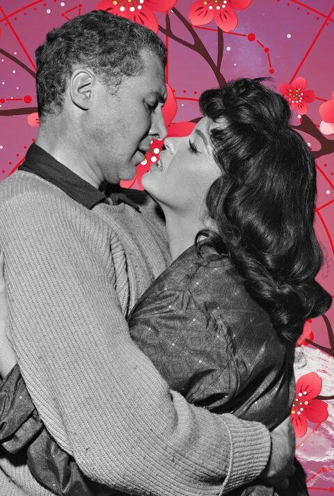 Schwarz-weißes Vintage-Foto eines sich innig umarmenden Paares vor einem rosafarben-violetten astrologischen Hintergrund mit Tierkreiszeichen und blühenden Kirschblüten – symbolisiert Liebe, Nähe und romantische Verbundenheit.“