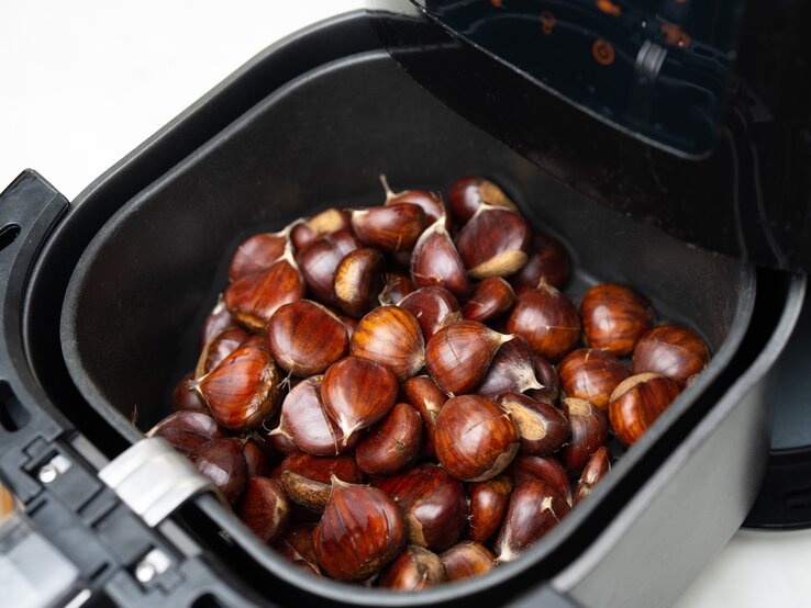 Maronen Airfryer Viele Maronen in einem Korb in einem Airfryer.