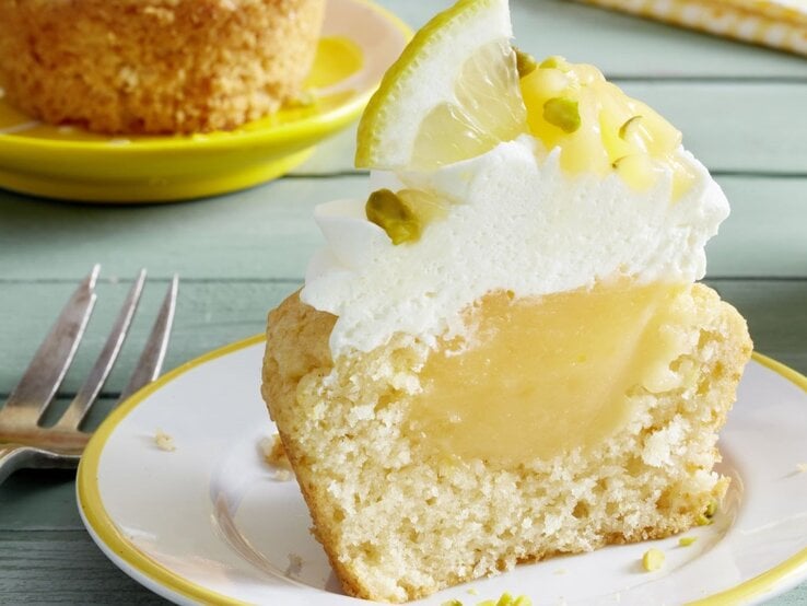 Ein Cupcake auf einem hellen Teller und hellgrünem Holztisch fotografiert