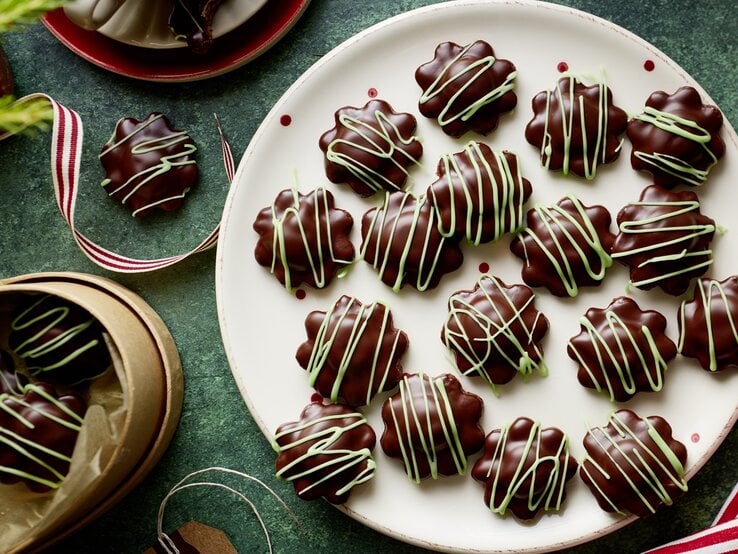 Die Kekse auf einem Teller mit weihnachtlicher Deko drumherum. Alles direkt von oben fotografiert.