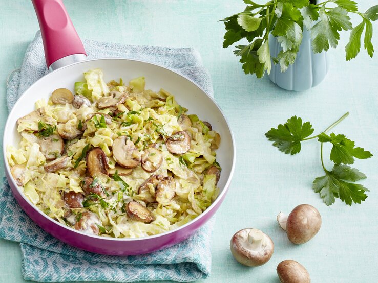 Das Pfannengericht auf einem hellblauen Tisch von schräg oben fotografiert.