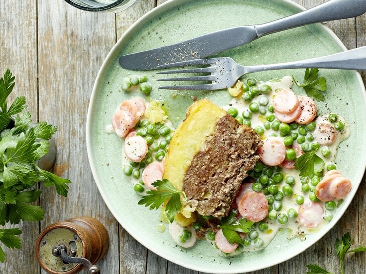 Ein hellgrüner Teller auf einem Holztisch mit dem Gericht direkt von oben fotografiert.