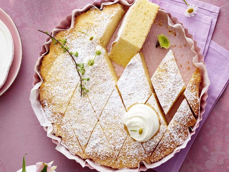 Der Kuchen in Rauten geschnitten auf einem violetten Untergrund direkt von oben fotografiert.