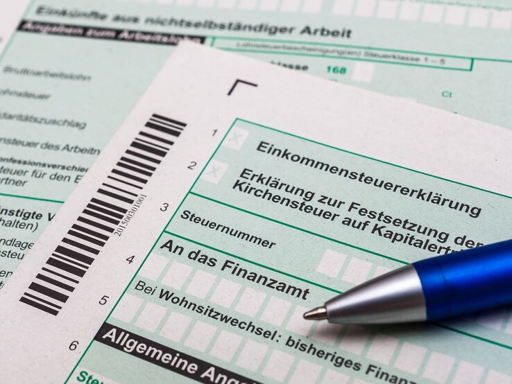 Steuererklärung Arbeitslosigkeit, Einkommensteuererklärung bei Arbeitslosigkeit Nahaufnahme von deutschen Steuerformularen zur Einkommensteuererklärung mit einem blauen Kugelschreiber darauf.