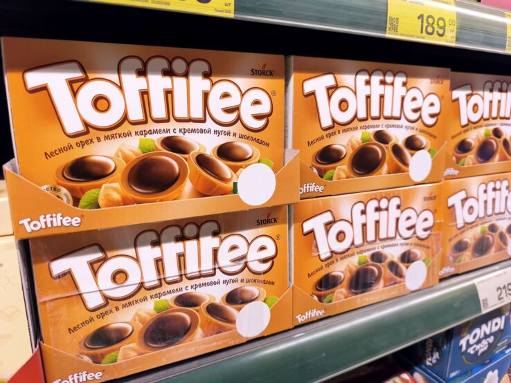 Toffifee Verpackung Basteln Upcycling DIY Nahaufnahme eines Supermarktregals mit orangefarbenen Toffifee-Schachteln und Preisschildern in kyrillischer Schrift.