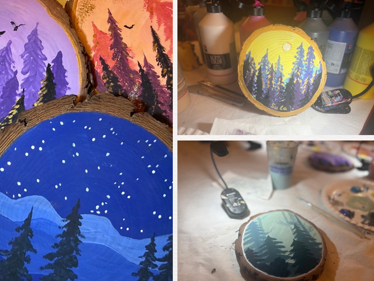 Bemalte Holzscheiben zeigen stilisierte Waldlandschaften mit Tannen farbigem Himmel und Sternen über verschneiten Hügeln.