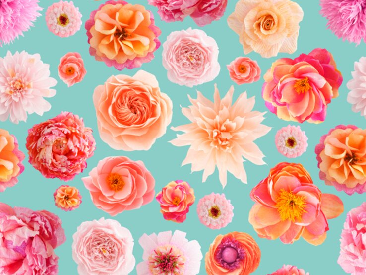 Verschiedene handgebastelte Papierblumen in Rosa-, Creme- und Orangetönen auf blauem Hintergrund.