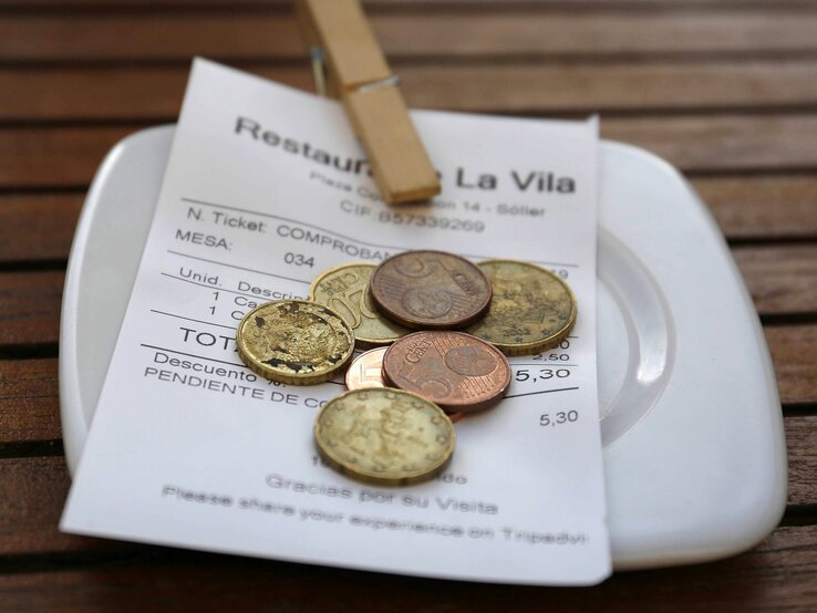 Eine Trinkgeldschale mit Bon und Kleingeld auf einem Tisch