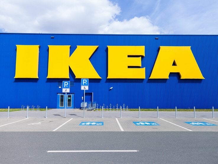 IKEA-Möbelhausfront in Blau mit gelben Lettern und Behindertenparkplätzen, keine Menschen.