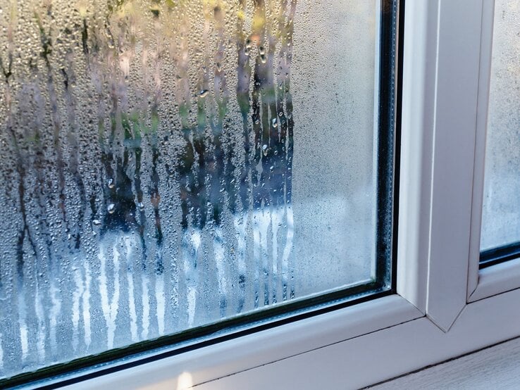 Kondenswasser am Fenster Kondenswasser läuft an einer beschlagenen Fensterscheibe herab.