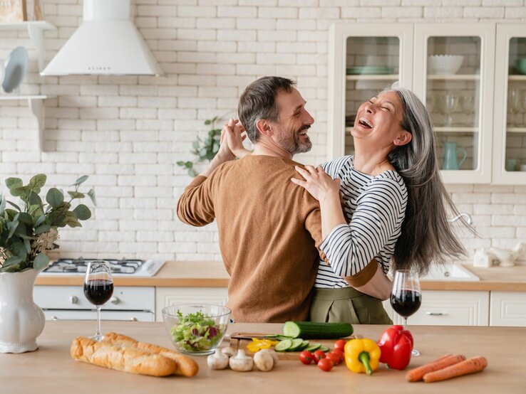 Ein fröhliches Paar tanzt gemeinsam in der Küche.