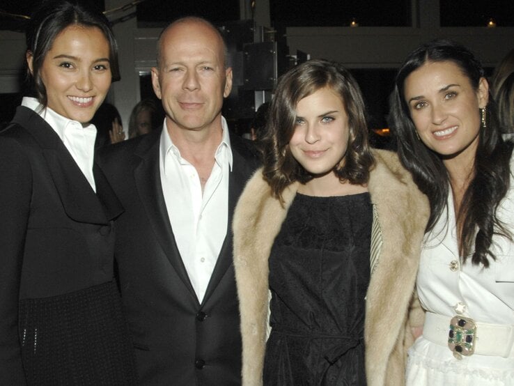 Vier Personen in eleganter Abendgarderobe stehen nebeneinander, zwei Frauen tragen Schwarz, eine Weiß, die vierte eine Felljacke.