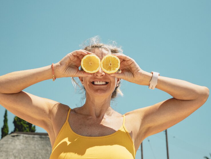 Nagellacktrend, Lemonade Nails Frau hält sich Zitronen vor die Augen