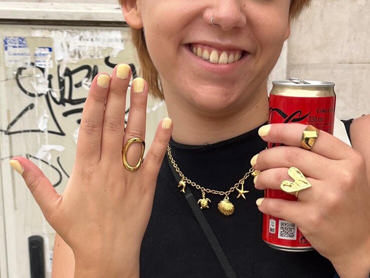 Hände mit gelb lackierten Nägeln tragen Goldschmuck, halten eine Cola-Dose und heben sich vor einem graffiti-verzierten Hintergrund ab. | © BILD der FRAU/ Kaja Wundersitz