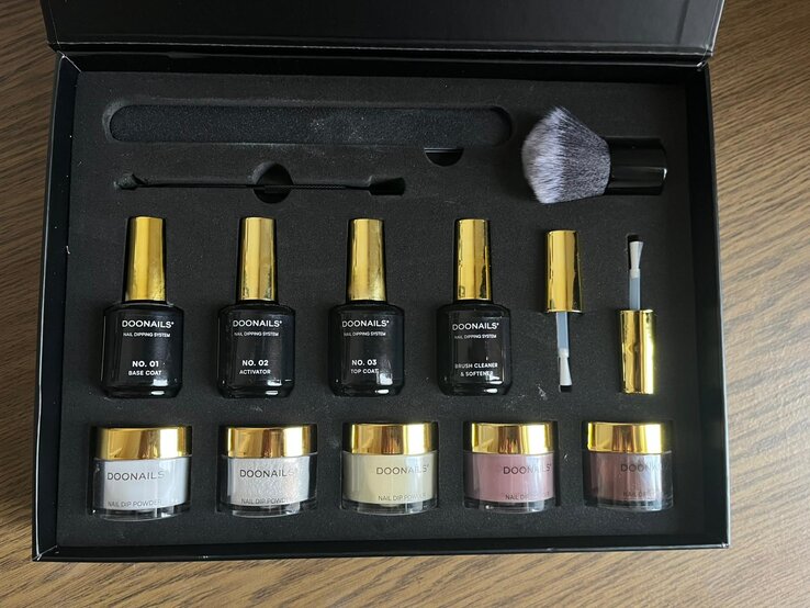 Nageldesign-Set mit Base Coat, Activator, Top Coat, vier Dipping-Puder-Dosen und Zubehör perfekt angeordnet in einer Box. | © BILD der FRAU/ Kaja Wundersitz