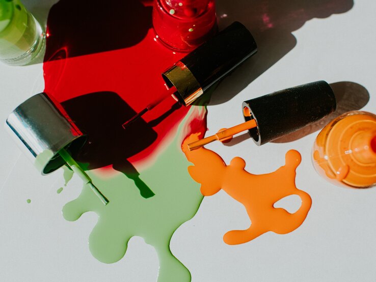 Zu sehen sind verschiedene Nagellackfarben, die teilweise ausgelaufen sind.