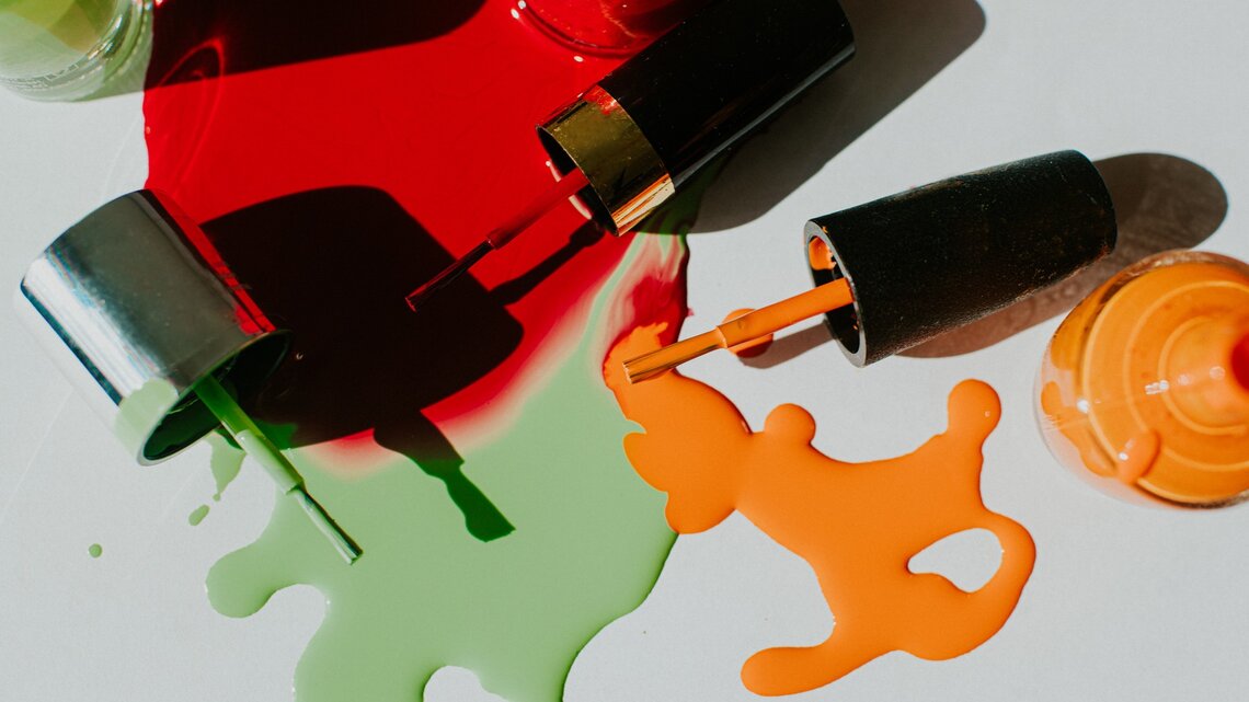 Zu sehen sind verschiedene Nagellackfarben, die teilweise ausgelaufen sind.
