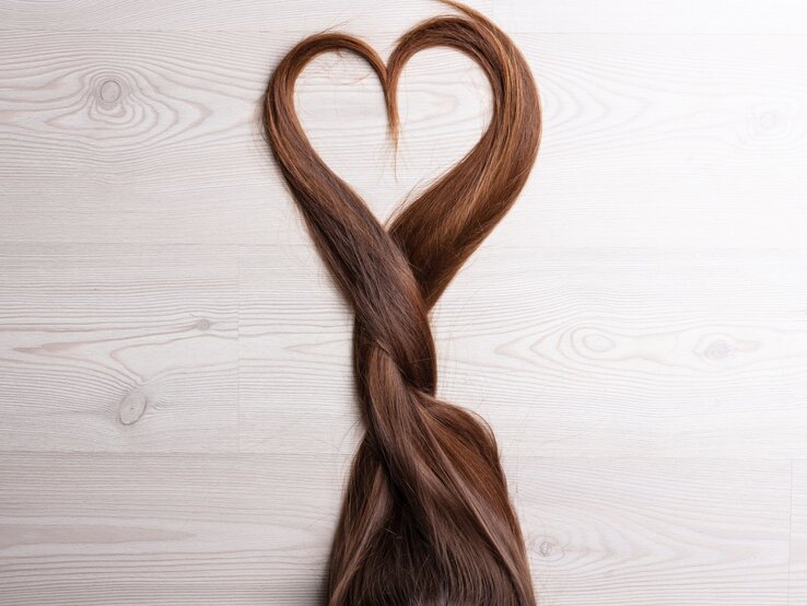 Zu sehen sind braune Haare, die ein Herz formen.