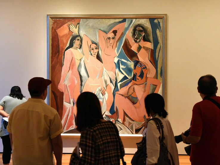 Besucher betrachten ein großes expressionistisches Gemälde von Pablo Picasso in einer Kunstgalerie.